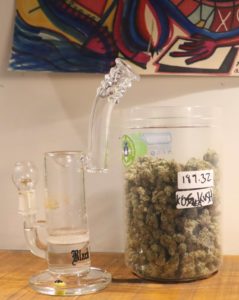 Jar filled with Kush Strain and glass bong